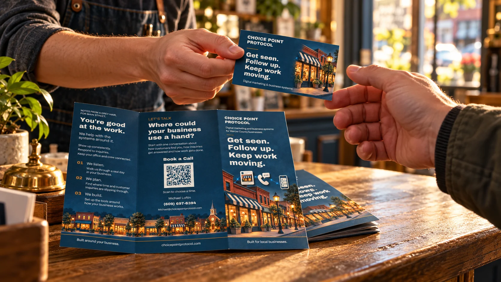Staged scene of CPP business cards being exchanged beside an open trifold on a shop counter
